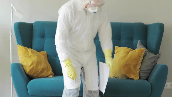 Doctor in Protective Suit with Inscription Hashtag Stay at Home Sitting on Sofa.
