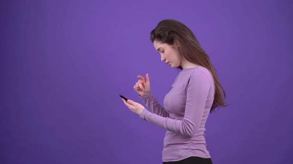 The Charismatic Girl in Profile with the Phone in Hand Surfs the Internet Looking for the Location alt