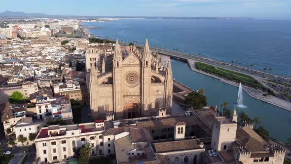Aerial circling shot of front facade of Cathedral of St. Mary of Palma, Spain alt