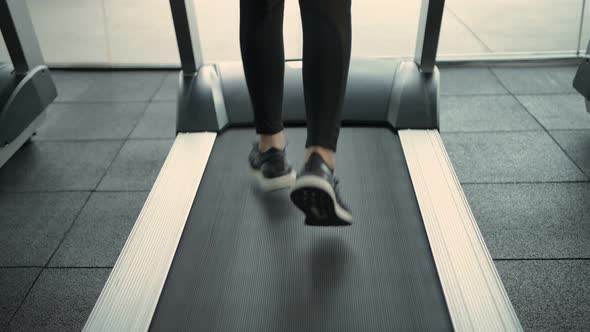 Fitness concept. close up feet are running on a treadmill alt