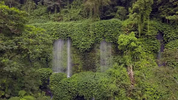 Slow motion of a waterfall on the mountain.Great aerial view flight pull back drone footageWaterfa alt
