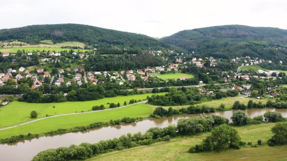 Aerial Drone Shot  a Picturesque Town Surrounded By Forests in a Hilly Rural Area alt