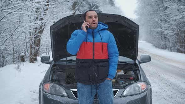 Angry Man Calls on the Phone Near the Broken Car
