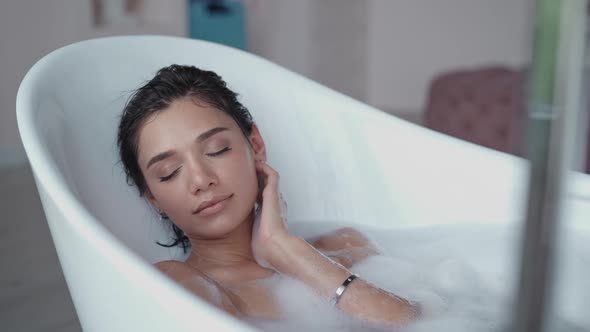 Close Up Relaxed Woman Touching Skin with Foam in Bath