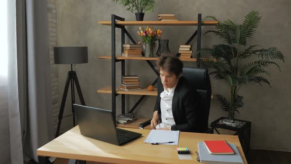 Young Attractive Businessman is Resting From Work with His Legs on the Table