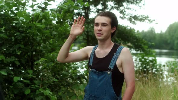 A Guy in a Farm Jumpsuit Waves Someone's Hand As a Sign of Greeting