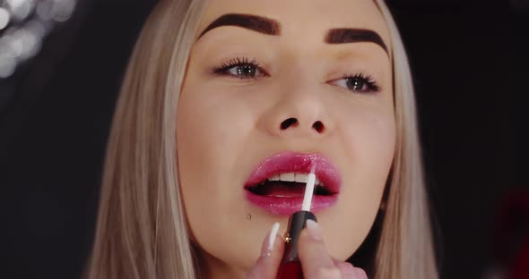 Young Beautiful Girl Paints Lips, Close Up. Makeup alt