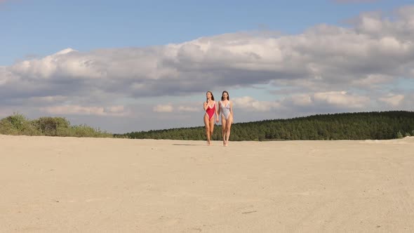 Sexy Women in Swimsuits Walking on Beach