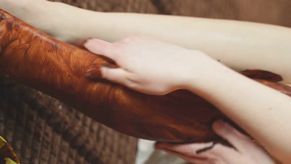 Woman Does a Spa Treatment Using Chocolate Paste at the Spa alt