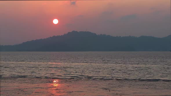 Timelapse Pink Sunset on the Shore of a Calm Sea the Sun Sets Behind the Mountain alt
