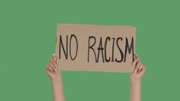 Sign NO RACISM Against the Background of a Green Screen, Chroma Key. Hands Hold Poster From a alt