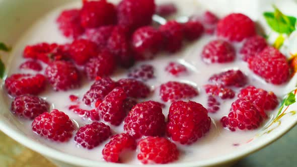 Close-up of raspberries in milk on the table. milk dessert with raspberries. macro of fresh raspberr alt