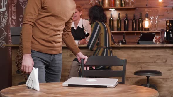 Young Man in a Coffee Shop Opening His Laptop alt