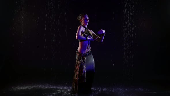 Enigmatic Arabic Dancer Woman is Dancing Under Rain at Night Moving Slowly alt