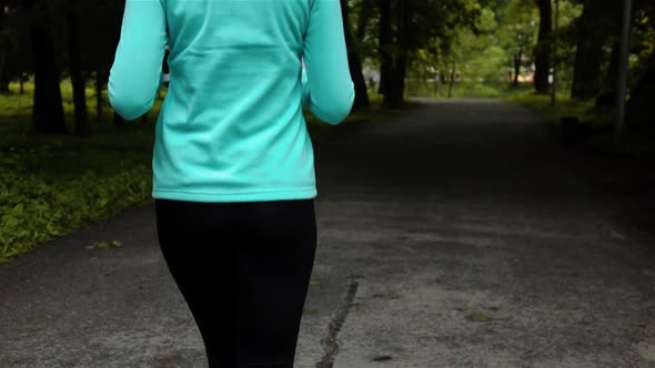 Happy Sporty Woman in Smal Headphone Outdoors in Park alt
