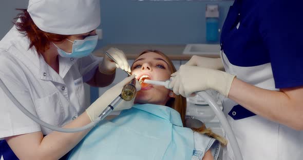Dentist Performs Professional Teeth Cleaning for Patient in Dental Office alt