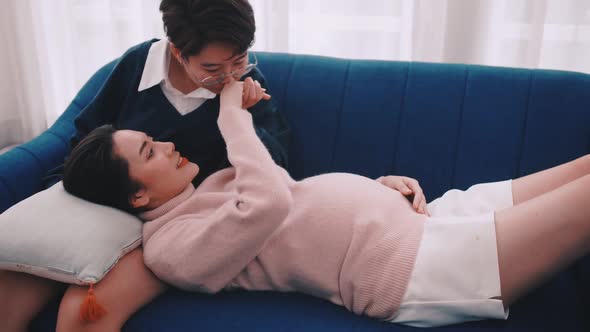 Pregnant Asian lesbian woman and her partner are happy to spend time together at home. alt