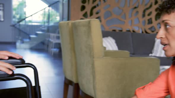 Close-up of African american mother consoling her disabled son in the lobby at hospital 4k alt