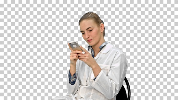 Young woman surgeon doctor reading sms on cell phone, Alpha Channel