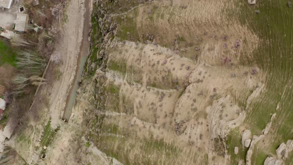 Top View Flight Over a Beautiful Sandy Rocky Cliff and an Open Water Canal Created By Man in