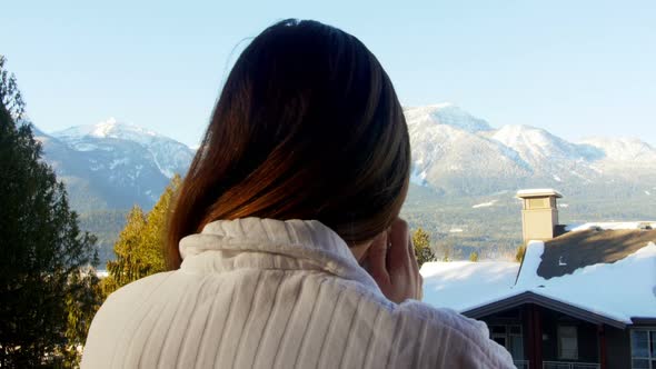 Woman having coffee in balcony alt