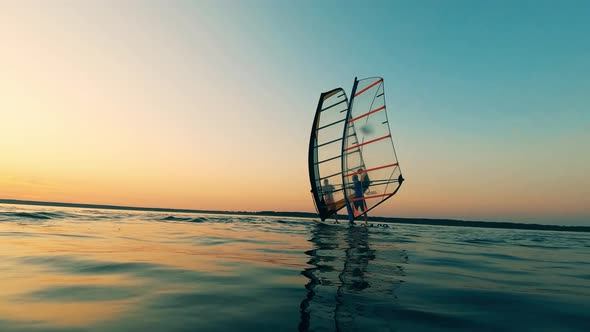 Two Men Are Standing on Sailing Windsurf Boards alt