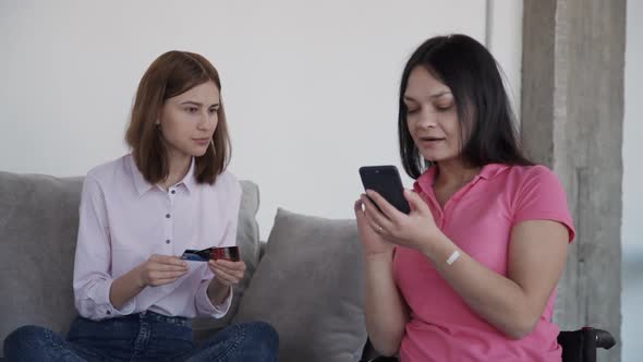 Woman in Comfort Wheelchair Making Online Shopping with Friend