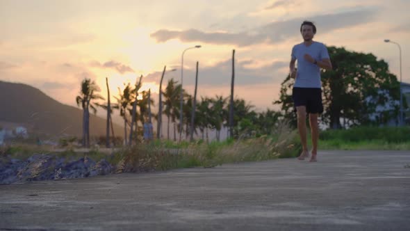 Slow Motion Shot of a Young Man Running Barefoot alt