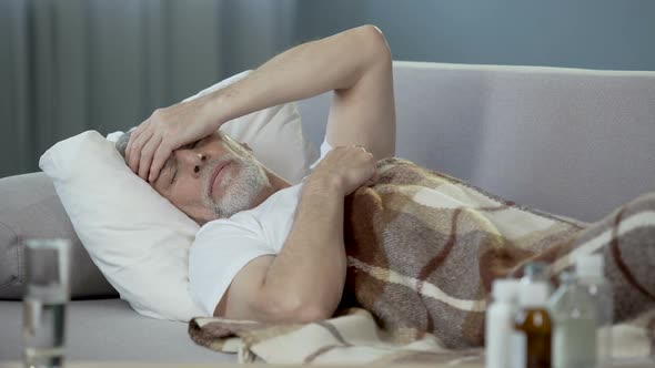 Old Person Sleeping in Bed and Suffering From Terrible Headache, Illness alt