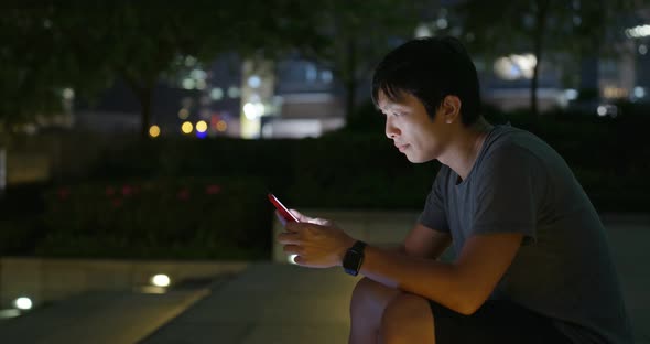Asian man use of mobile phone in city at night alt