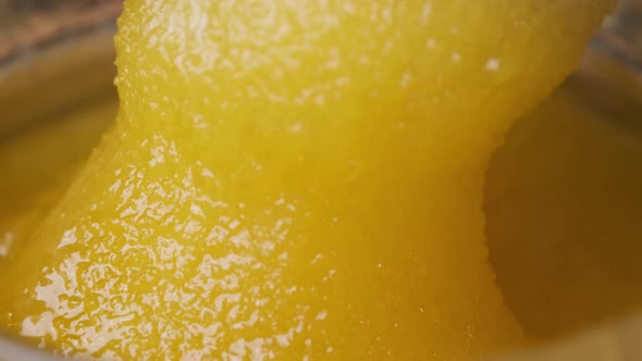 Crystalline Honey in a Jar, Macro, The Spoon is Dipped in thick Honey alt