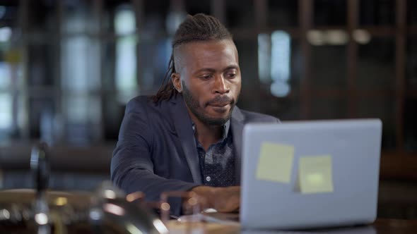 Portrait of Successful Positive African American Freelancer Sending Email Closing Laptop Ordering alt