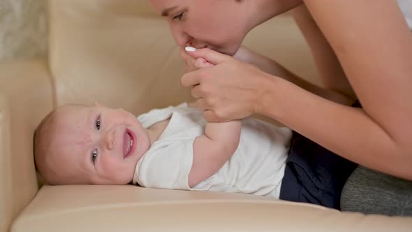 Young mother gently kissing baby enjoying loving mom alt