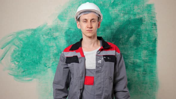 Joyful Builder Holds Green Paintbrush Showing Thumbup alt