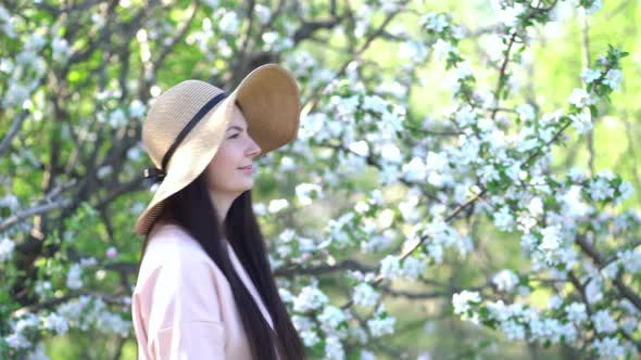 Beauty Young Woman Enjoying Apple Blooming Spring Orchard. alt
