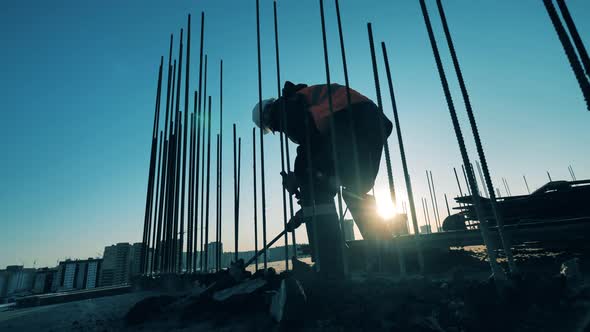 Construction Worker with Demolition Hammer Breaking Part of a Building. alt