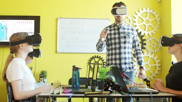 Students and Teacher Using VR Goggles in Classroom