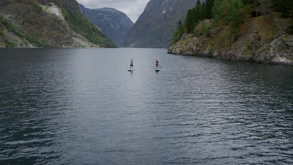 Two People on SUP Baddle Board in Norwegian Fjord alt