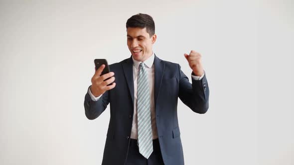 Happy Male Office Worker in Formal Clothes Uses Mobile Phone Rejoices in Victory alt