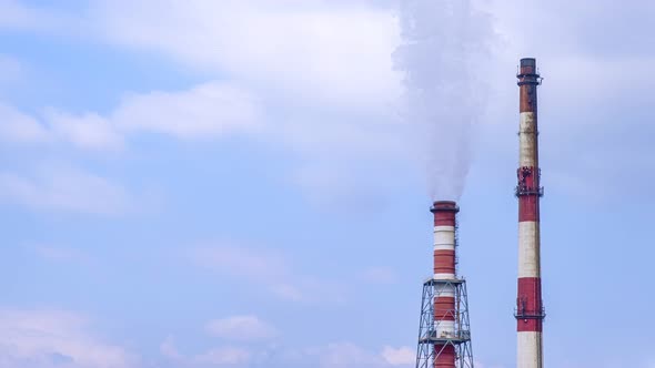 Timelapse Footage of Two Chimneys of Combined Heat and Power Station at Blue Sky and Clouds alt