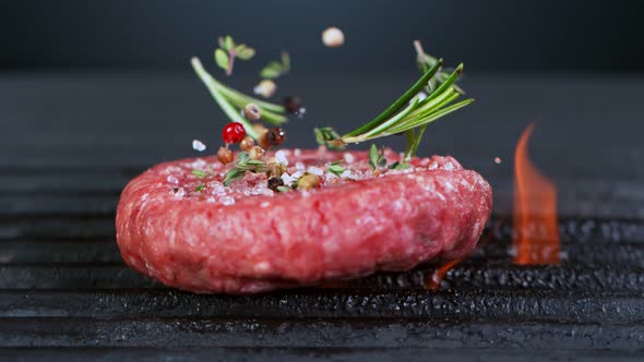 Super Slow Motion Shot of Falling Fresh Beef Hamburger Meat with Herbs on Grill at 1000 Fps alt
