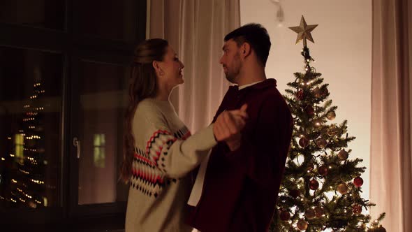 Happy Couple Dancing Near Christmas Tree at Home