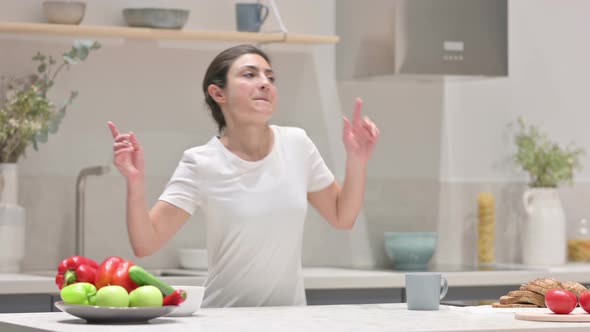 Young Indian Woman Dancing While Standing in Kitchen alt