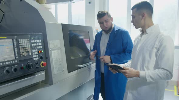 Industrial Employees with Tablet Inspecting Factory Equipment