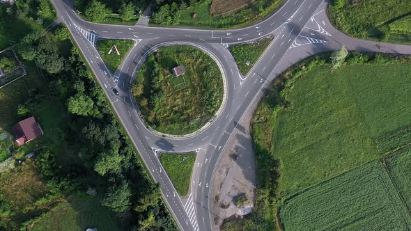 Roundabout traffic of cars and trucks on the circle ring road aerial top view. alt