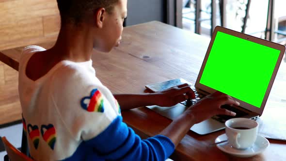Woman using laptop with green screen alt