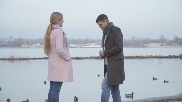 Handsome Young Caucasian Man Standing on One Knee and Giving Wedding Ring To Older Woman. Elegant alt