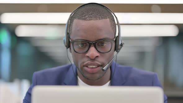 Portrait of African Businessman with Laptop Talking on Headset alt