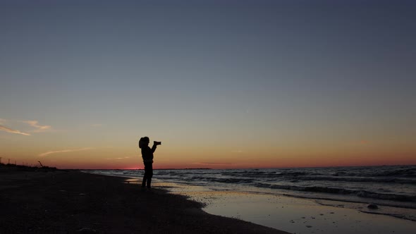 Silhouette of an Independent and Modern Woman Photographer a Travel Correspondent Photographing the alt