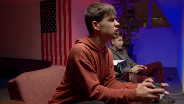 Nervous Young Man with Gamepad Playing Videogame